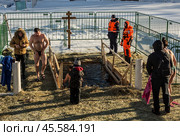 Люди купаются в проруби на праздник Крещения в Воронцовском парке, Москва (2022 год)./ Epiphany bathing in the ice hole in the Vorontsovo estate, Moscow. Редакционное фото, фотограф Iva Noel / Фотобанк Лори
