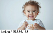 Adorable baby smiling and holding a squeezable food pouch in hands for infant nutrition concept. Стоковое AI-изображение, AI-художник Sabyna75 / Фотобанк Лори
