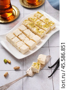 Turkish vatka - tender pashmak halva on a plate, in the form of square cubes, with a cup of Turkish tea. Стоковое фото, фотограф Евгения Трушкова / Фотобанк Лори