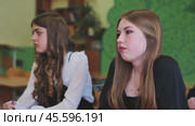 Two attentive high school girls actively engaged in a classroom lesson, absorbing the teacher's instruction during the school day. Стоковое видео, видеограф Mikhail Davidovich / Фотобанк Лори
