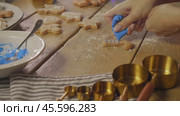 Cook applies strips of blue glaze to the ginger biscuits, giving them a bright color and a unique, sweet Christmas flavor. Стоковое видео, видеограф Strunov David / Фотобанк Лори