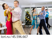 Couples dancing during Christmas - men and women dancing tango or samba next to Christmas tree. Стоковое фото, фотограф Яков Филимонов / Фотобанк Лори