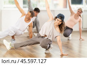 Girl and her students perform hip hop dance on one bent leg, movement in horizontal plane near floor. Стоковое фото, фотограф Яков Филимонов / Фотобанк Лори
