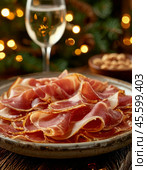 Thin slices of jamon. Jamon (in Spanish jamon - "ham") is a national dish of Spain, a dry-cured pork leg. Only the hind legs of the pig are used for jamon, which are dried whole. Enjoy your meal! Стоковое AI-изображение, AI-художник Сергей Елизарьев / Фотобанк Лори
