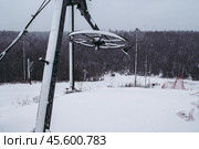 Skiing drag lift on top of mountains slope. mechanism of drag lift upper station at snowboard sport centre. small ski resort. Scenery view on downhill during snowfall. Стоковое фото, фотограф Константин Григорьев / Фотобанк Лори