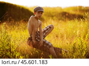 Teenager sits on driftwood. Стоковое фото, фотограф Дмитрий Киселёв / Фотобанк Лори