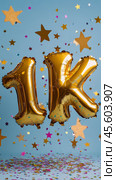 Celebration with golden balloons marking achievement of 1K on a festive backdrop. Стоковое AI-изображение, AI-художник Юлия Гапеенко / Фотобанк Лори