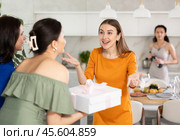 Two women have arrived for birthday celebration and presenting gift to birthday woman. Стоковое фото, фотограф Яков Филимонов / Фотобанк Лори