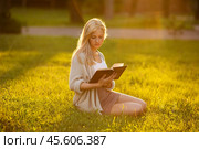 Girl sitting on the grass and reading a book. Стоковое фото, фотограф Дмитрий Киселёв / Фотобанк Лори