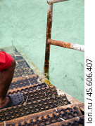 A person donning crocs can be observed standing on a staircase. Стоковое фото, фотограф Igor Bastrakov / Фотобанк Лори