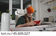 Teenage gamer enjoys gaming on smartphone, highlighting evolution of portable gaming devices. With intense focus explores virtual world of mobile esports. Gadgets and focus elevate gaming experience. Стоковое видео, видеограф Енваев Андрей / Фотобанк Лори