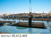Погрузка угля навалом, портовыми кранами в трюмы морского грузового судна в морском порту. Стоковое фото, фотограф Павел Просянов / Фотобанк Лори
