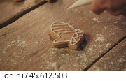 Ginger cookies in the shape of a winter glove are decorated with cream, giving them a festive Christmas look. Стоковое видео, видеограф Strunov David / Фотобанк Лори