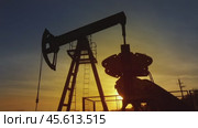 Working oil pump silhouette against sunset. Стоковое видео, видеограф Михаил Коханчиков / Фотобанк Лори