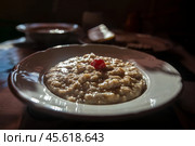 Oatmeal porridge with dried cherries in white plate. Cooked whole porridge oats. healthy and natural breakfast. Стоковое фото, фотограф Константин Григорьев / Фотобанк Лори