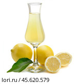 Limoncello in stemmed glass with lemons and leaf on white background. Стоковое AI-изображение, AI-художник Иван Рябоконь / Фотобанк Лори
