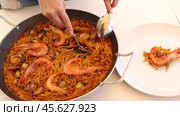 Womens hands lay out sea pasta in plates for family dinner. Стоковое видео, видеограф Яков Филимонов / Фотобанк Лори