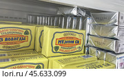 Moscow December 04, 2024, Butter in packaging on a store counter. Concept of increasing prices for butter. Refrigerator in a grocery store with briquettes of natural butter. Редакционное фото, фотограф Скрипачев Антон / Фотобанк Лори