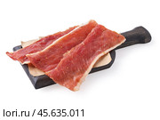 Three pieces of raw smoked pork chips on a wooden board isolated on a white background, sharpness across the object. Стоковое фото, фотограф Сергей Чайко / Фотобанк Лори