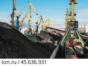 Горы угля в морском порту, грузовые вагоны с углем, телескопические ленточные транспортеры, которые перераспределяют уголь по участку. Стоковое фото, фотограф Павел Просянов / Фотобанк Лори