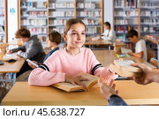Ten-year-old schoolgirl passes books to the librarian. Стоковое фото, фотограф Яков Филимонов / Фотобанк Лори