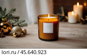 A mock-up of a cozy burning candle made of amber glass with an empty white label in a festive, New Year's home interior. Стоковое AI-изображение, AI-художник Photojuli / Фотобанк Лори