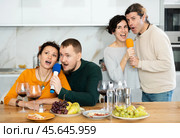 Group of friends are having fun singing karaoke during feast and gatherings. Стоковое фото, фотограф Яков Филимонов / Фотобанк Лори