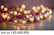 The concept of Valentine's Day, a banner with garlands in the form of hearts and magic lights for a holiday filled with love. A place for the text. Стоковое AI-изображение, AI-художник Photojuli / Фотобанк Лори