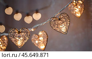 The concept of Valentine's Day, a banner with garlands in the form of hearts and magic lights for a holiday filled with love. A place for the text. Стоковое AI-изображение, AI-художник Photojuli / Фотобанк Лори