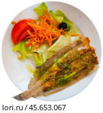 There is plate with fried solea flatfish and salad of fresh veg on wooden table. Стоковое фото, фотограф Яков Филимонов / Фотобанк Лори