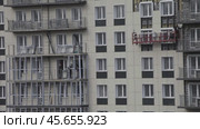 ANGARSK, IRKUTSK REGION, RUSSIA- October 08, 2024: Video of  builders work on new high-rise residential building: tiling the facade, glazing balconies and windows. Housing construction concept. Редакционное видео, видеограф Виктория Катьянова / Фотобанк Лори