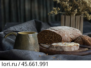 Натюрморт с батоном хлеба на деревянной дощечке и кружкой. Натуральные материалы. Стоковое фото, фотограф Евгений Зимин / Фотобанк Лори