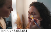 Makeup artist paints the girl with a pencil and shading the pigment with a brush. Стоковое видео, видеограф svetograph / Фотобанк Лори