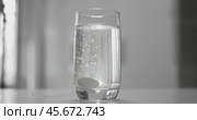 Effervescent aspirin pill in a glass of wate. Soluble tablet shot on super slow motion camera 1000 fps. Стоковое видео, видеограф Андрей Армягов / Фотобанк Лори