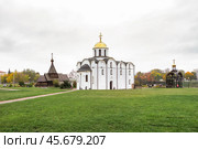 Благовещенская церковь в историческом районе  Витебска с белокаменным фасадом и золотым куполом на фоне зелёного парка и деревянной церкви в честь князя Александра Невского. Редакционное фото, фотограф Сергей Никифоров-Гордеев / Фотобанк Лори