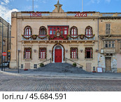 Historic Maltese Building Decorated for Christmas with Festive Garlands and Red Accents. Стоковое фото, фотограф Kira_Yan / Фотобанк Лори
