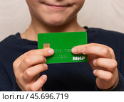 Мальчик держит в руках пластиковую карточку. Редакционное фото, фотограф Игорь Низов / Фотобанк Лори