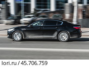 Kia Quoris first generation KH in the city street. Black Kia K900 car with man driver rides on the road to the work (2021 год). Редакционное фото, фотограф Константин Григорьев / Фотобанк Лори