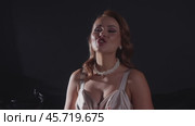 An attractive young singer actively gestures with her hands while singing, and looks directly into the camera. Стоковое видео, видеограф Strunov David / Фотобанк Лори