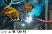 Metal welding. Workers wearing uniforms and Welded Iron Mask at Steel welding plants, industrial safety first concept. Welder With Torch. Production environment, with blue sparks flying. Copy space. Стоковое AI-видео, аниматор Марина Демидюк / Фотобанк Лори