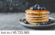 Homemade Pancakes stack with blueberries and honey on a modern ceramic plate. Classic blueberry pancake stack filled with syrup among gray concrete wall background. Sweet breakfast with berry, fruit. Стоковое AI-видео, аниматор Марина Демидюк / Фотобанк Лори