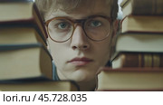 Student studying intensely surrounded by books in quiet library environment. Стоковое AI-видео, аниматор Ксения Лаптева / Фотобанк Лори