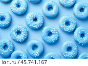 Delicious blue donuts forming a repetitive pattern on a vibrant background. Стоковое AI-изображение, AI-художник Иван Рябоконь / Фотобанк Лори