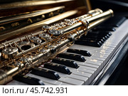Close-up of gold flute on black white piano keys. Flute with piano, wind instrument for musical design of concert creativity. Music orchestra concert concept. Copy ad text space. Copy ad text space. Стоковое AI-изображение, AI-художник Aleksandr Golubev / Фотобанк Лори