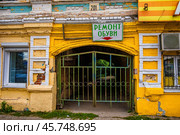 Вывеска ремонт обуви над аркой в старом доме (Дом Головастиковых в Богородске) (2024 год). Редакционное фото, фотограф Илья Старков / Фотобанк Лори