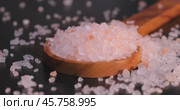 Himalayan pink salt in a wooden is used to flavor food. Due mainly to marketing costs, pink Himalayan salt is up to twenty times more expensive than table or sea salt. Стоковое видео, видеограф Андрей Армягов / Фотобанк Лори