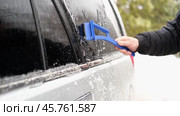 A man who thoroughly cleans his car of ice in winter using a special scraper. Advertising of car cosmetics, winter accessories and car repair services. Winter car care. Removing ice from a car. Banner. Стоковое видео, видеограф Евгений Демидюк / Фотобанк Лори