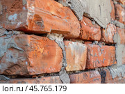 Close up of deteriorating red brick wall showing crumbling mortar. Стоковое AI-изображение, AI-художник Иван Рябоконь / Фотобанк Лори
