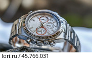 Luxury chronograph watch resting on rock, time and style. Стоковое AI-изображение, AI-художник Юрий Поздников / Фотобанк Лори
