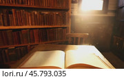 Open book appearing on a wooden table in a library. Стоковое видео, видеограф Данил Руденко / Фотобанк Лори